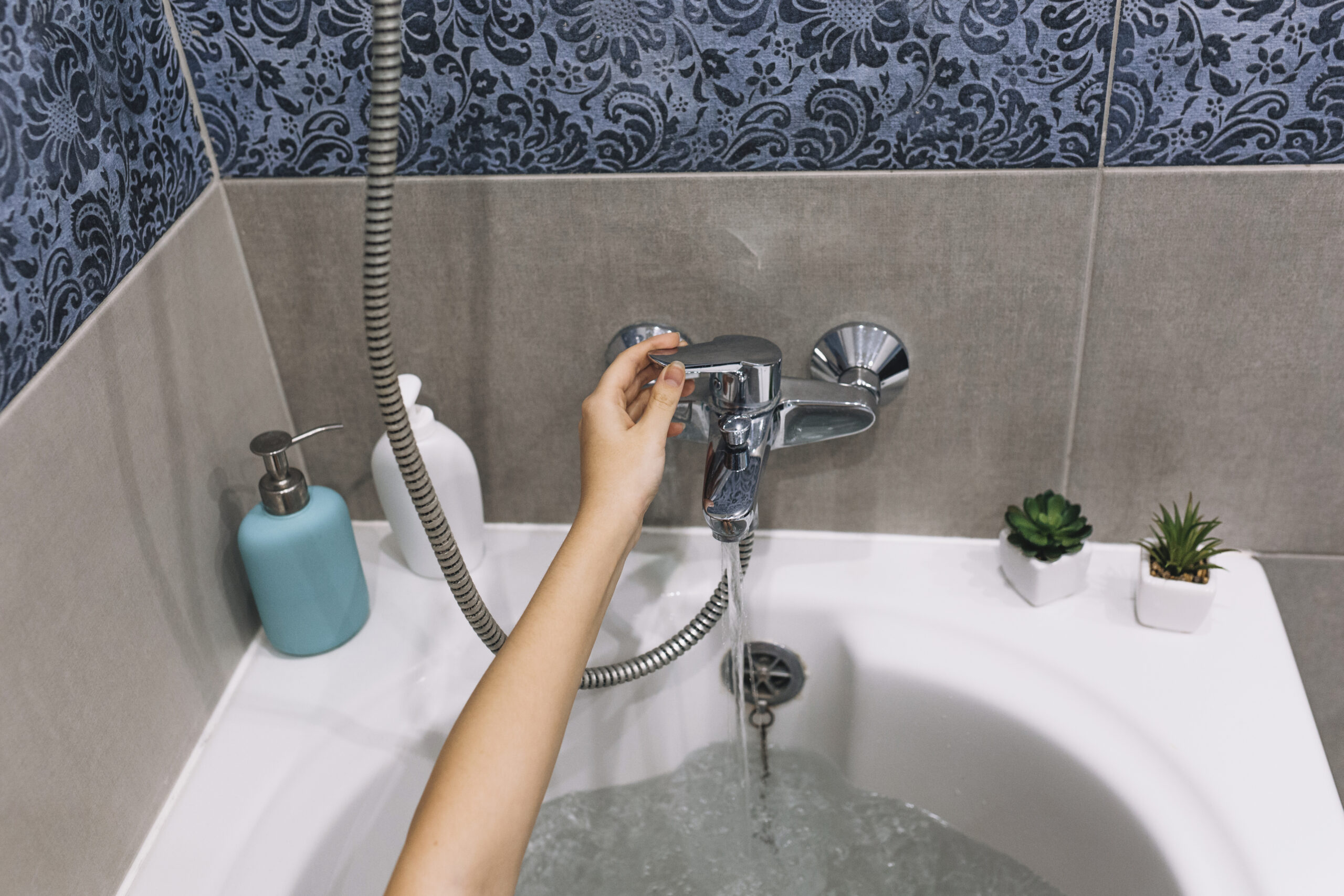 crop-hand-touching-bath-tap